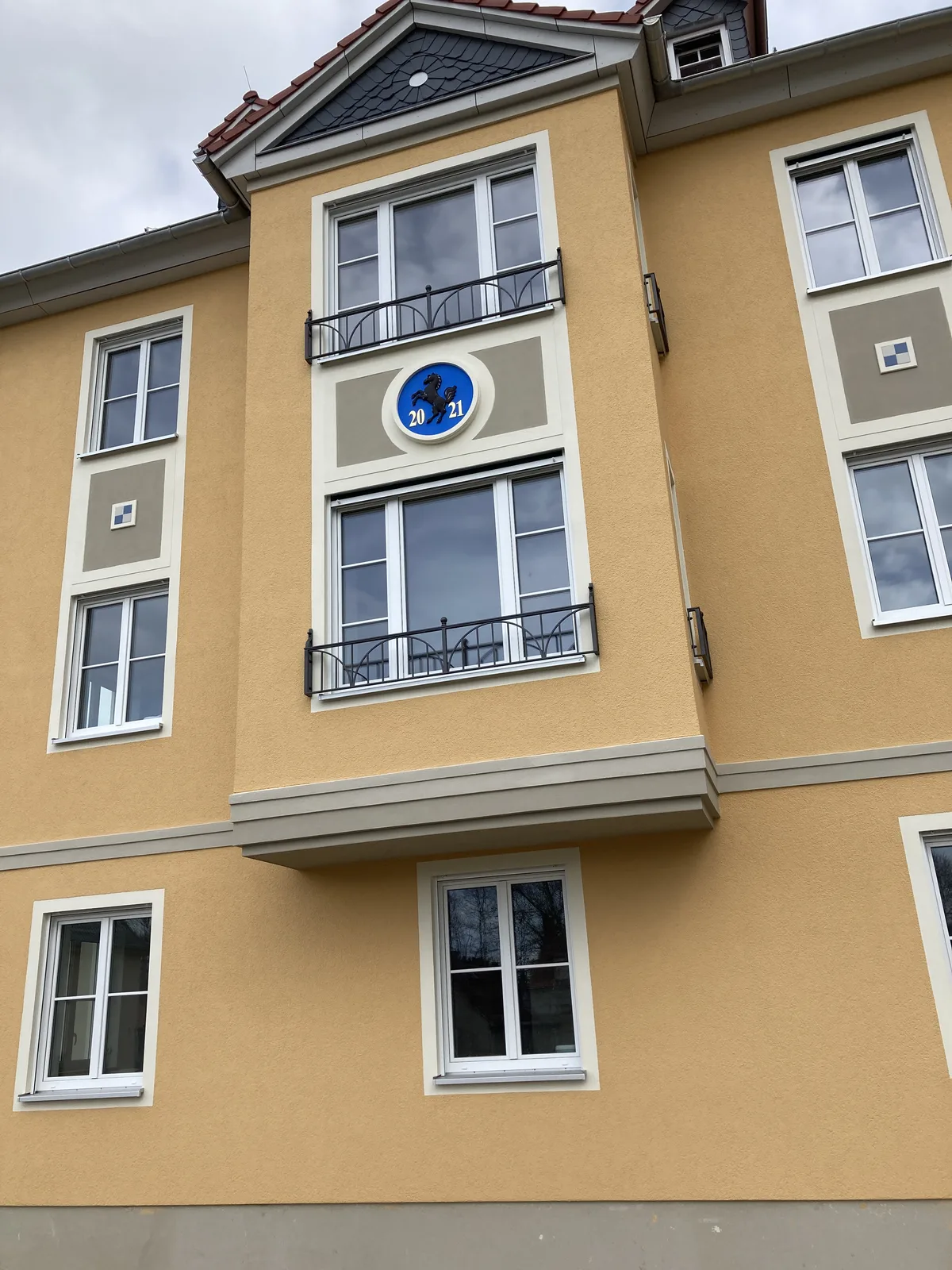 Wohnhausfassade mit bemaltem Wappenmedaillon