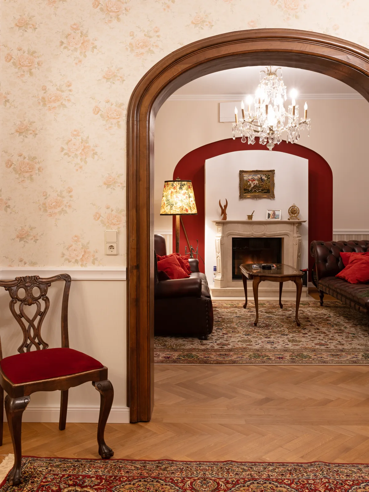 Wohnzimmer mit Kamin und rotem Bogendurchgang
