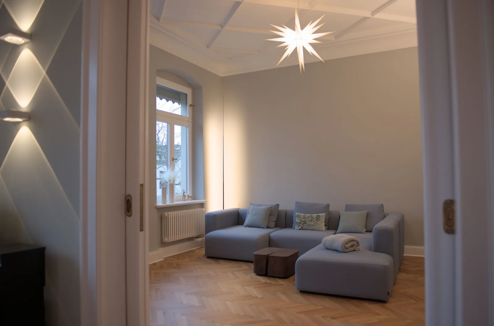 Wohnzimmer mit Sternenleuchte und blauen Sofas