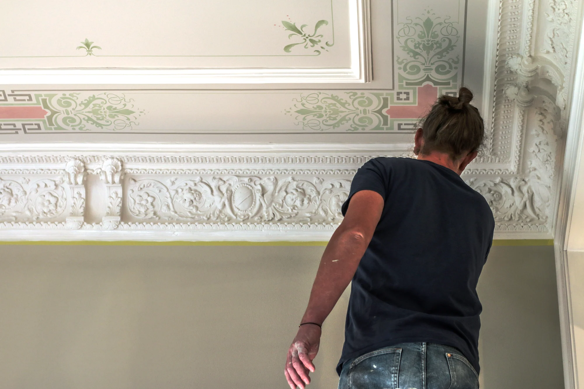 Handwerker bei Arbeiten an einer reich verzierten Stuckdecke mit ornamentaler Deckenmalerei